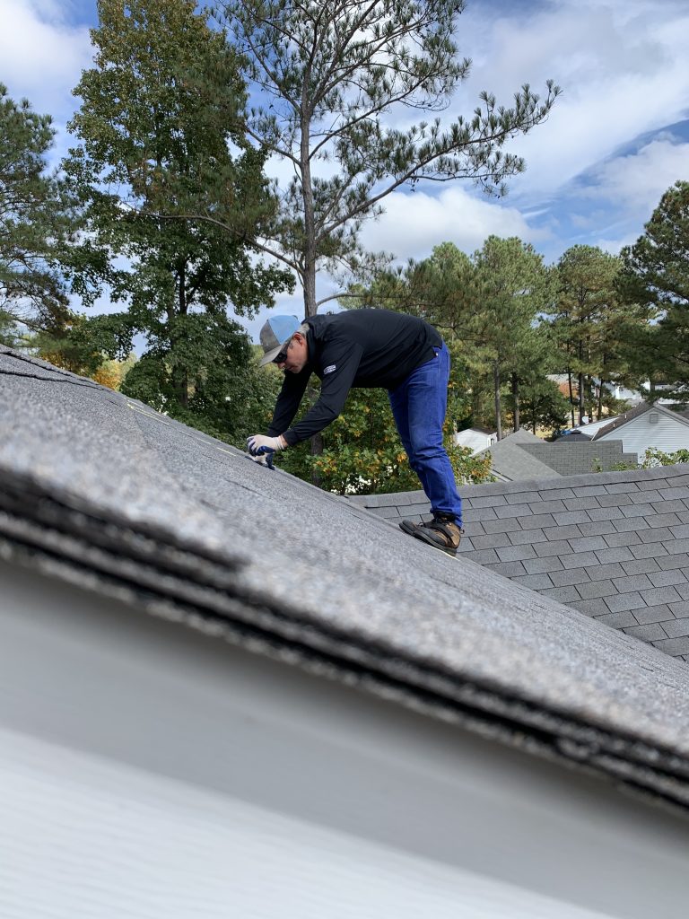 A member of the CIR team inspecting a home's roof